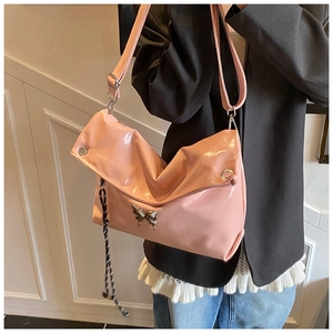 Détail du sac cabas rose brillant avec papillon en métal et tirette de zip tissée