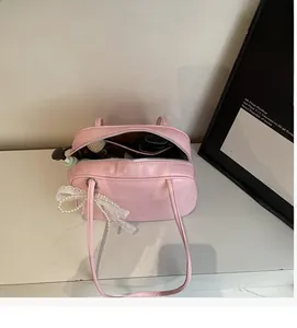 Detail shot of the spacious interior of a pink leather shoulder bag with top zipper
