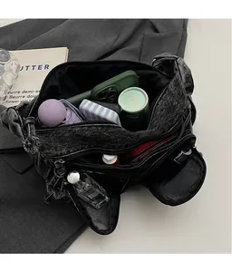 Detail view of denim shoulder bag interior showing large capacity for everyday items