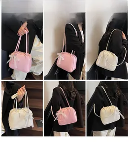 Detail showing the lace bow and pearl chain on a stylish solid color underarm bag