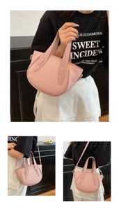 Detail of pink woven bucket bag showing leather handles and golden metal hardware