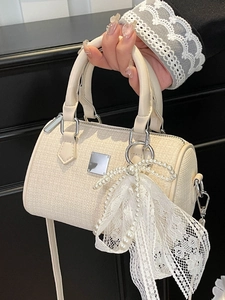 Elegant off-white woven Boston bag with pearl bow charm and cylinder handles