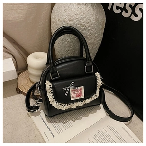 Detail of black Boston bag featuring lace pocket, checkered bow and cute rabbit patch