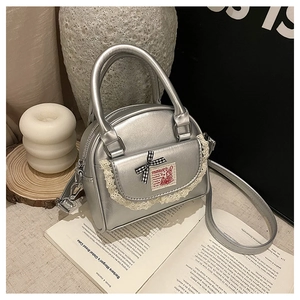 Detail of silver Boston bag featuring white lace trim and a cute rabbit illustration patch