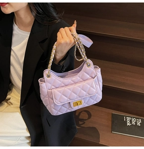 Close-up of lilac quilted leather shoulder bag with gold chain strap on steps