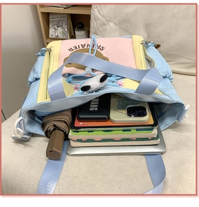 Gros plan du sac fourre-tout grande capacité avec ordinateur, livres et parapluie