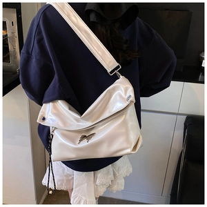 Détail du grand sac cabas en cuir blanc avec décoration de boucle papillon en métal