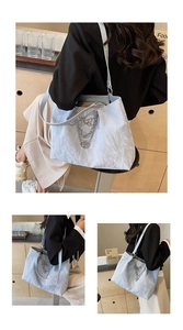 Close-up of light blue pleated tote bag featuring layered silver chains and butterfly charms