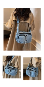 Detail view of the washed blue denim crossbody bag with multiple zippers and frayed edges