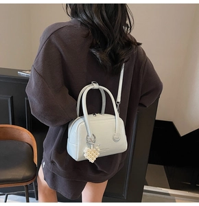 Detail of light blue pebble leather Boston bag featuring a pearl heart charm