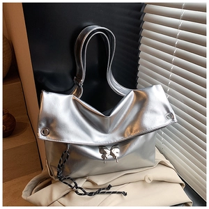 Détail du sac cabas argenté avec boucle papillon et breloque en corde tressée noire