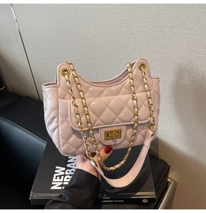 Close-up of light pink quilted shoulder bag with gold chain and square twist lock detail
