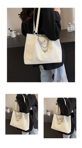 Close-up of white tote bag featuring marble wave texture and silver butterfly chain