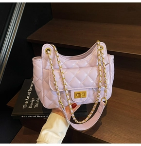Detail of light purple quilted handbag with gold chain strap and functional side pocket