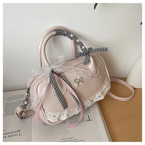 Detailed view of pink Boston bag with lace trim, bows, and silver butterfly buckle detail