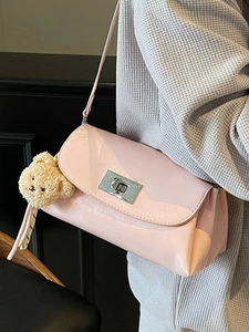 Pink faux leather pillow bag with silver turn-lock and brown teddy bear charm