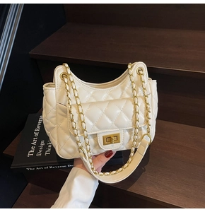 Close-up of quilted white leather chain bag featuring gold metal clasp and side pocket