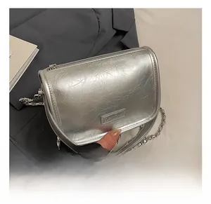 Detail of silver pleated leather pillow bag with metal chain and logo plaque