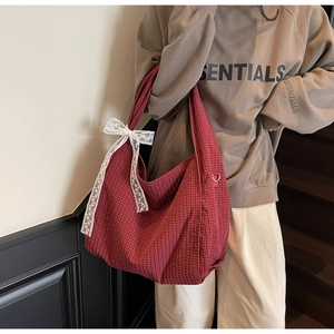 Detail of red checkered canvas tote bag with a white lace bow in retro style