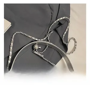 Detail showing metallic silver crinkle leather texture with stylish ball clasp and chain