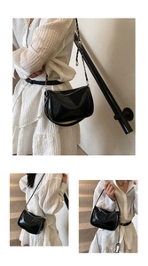 Close-up of black glossy leather pillow bag with silver chain strap and zipper detail