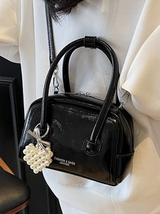 Glossy black patent leather pillow bag with pearl heart charm and silver bow accent