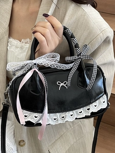 Elegant black Boston bag with ballet-style lace bows and checkered ribbon handle decor