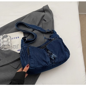 Close-up of retro denim crossbody bag with multiple zip pockets and adjustable strap
