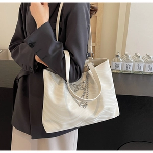Close-up of white wave-textured tote bag with butterfly metal chain and large capacity