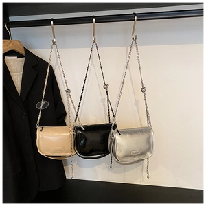 Three metallic pillow bags in gold, black and silver hanging with stylish chain straps