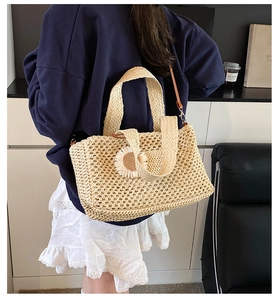 Détail du sac cabas en paille tissé avec décor marguerite blanche et bandoulière en cuir brun