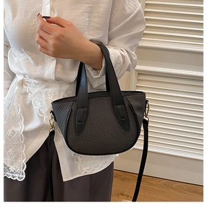 Detail showing high-quality houndstooth pattern bag with gold-tone hardware and black handles