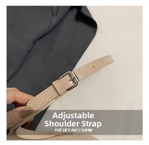 Detail of adjustable beige leather shoulder strap with silver metal buckle and fine stitching