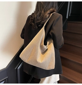Detail view of large metallic champagne hobo bag with textured fabric and soft drape