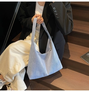 Lifestyle shot of a spacious light blue denim hobo bag with a wide shoulder strap