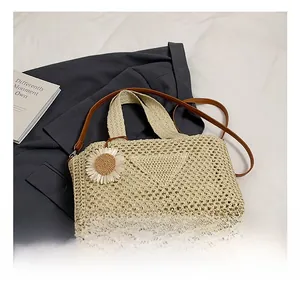 Détail du sac cabas en paille tissé avec fleur de marguerite et bandoulière en cuir