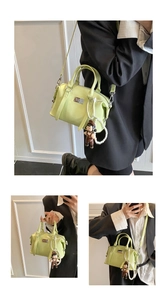 Three-way view of a light green patent leather Boston bag with pearl charm accessory