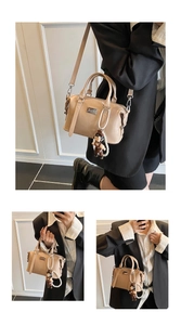 Detail view of beige Boston bag featuring a pearl chain and cute plush doll charm accessory