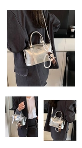 Detail view of silver metallic Boston bag with large pearl charm and cute plush pendant