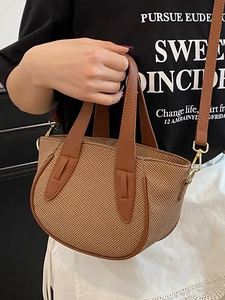 Brown woven bucket bag with smooth leather trim and adjustable crossbody strap