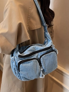 Light blue denim crossbody bag with multiple pockets and adjustable strap shown on model