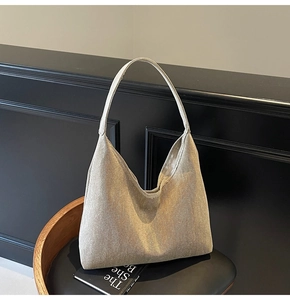Detailed view of the sparkling beige hobo bag with textured fabric on a stylish black chair
