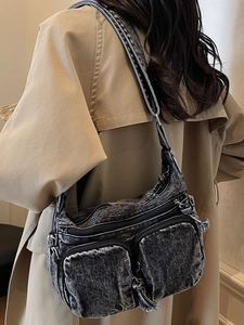 Vintage dark gray denim crossbody bag with multiple zip pockets shown on model shoulder