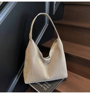 Close-up of beige canvas hobo tote bag texture on dark wood stairs background