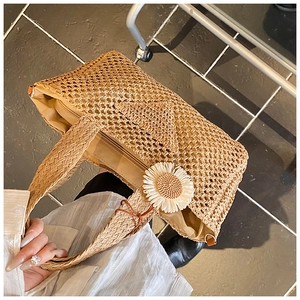 Détail du sac cabas en paille avec fleur de marguerite blanche et fermeture éclair