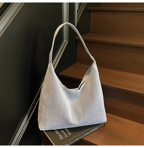 Detail of light blue denim hobo bag on rustic wooden steps for casual daily use