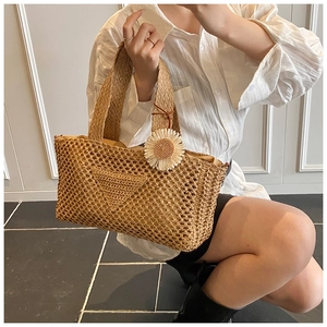 Vue détaillée du sac en paille avec charm marguerite et motif triangulaire