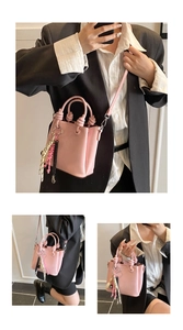 Sac seau rose avec poignée nouée, breloque en corde tressée et pendentif cœur sur blazer noir