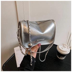 Close-up of metallic silver pillow bag with chain strap and luxury crinkled leather detail