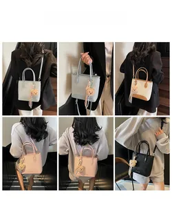 Detail view of woven bucket bag in four colors with bear pendant and detachable strap